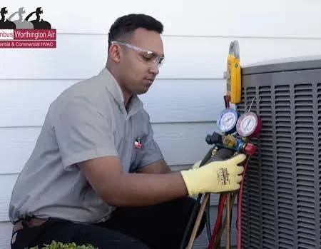 HVAC technician checking refrigerant pressure readings beside a condenser